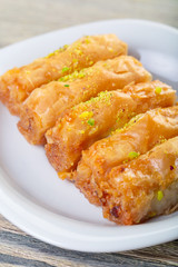 Traditional arabic dessert baklava with cashew, walnuts and cardamom with an eucalyptus branch on a wooden table