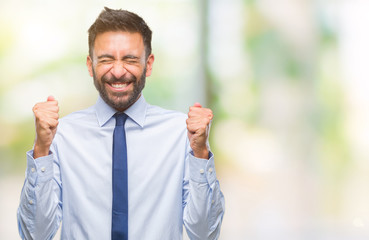 Adult hispanic business man over isolated background excited for success with arms raised...