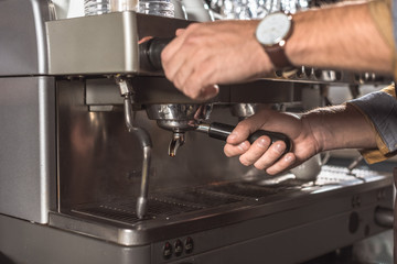 cropped shot of barista using coffee machine in restaurant