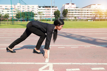 Business competition: businesswoman on start line and ready to reach the target.