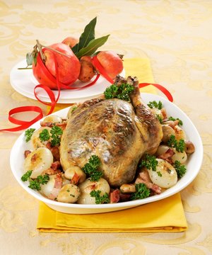 Capon with potatoes, onions and bacon for Christmas