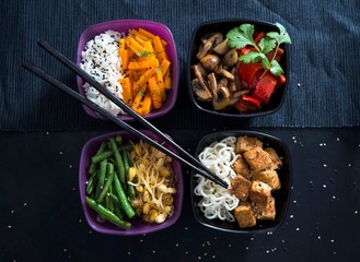 Four bowls with rice, roasted carrots, mushrooms, peppers, beans, mung beans, Mie noodles and tofu (Vegan)
