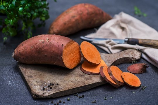 Sweet potato, sliced, on a chopping board