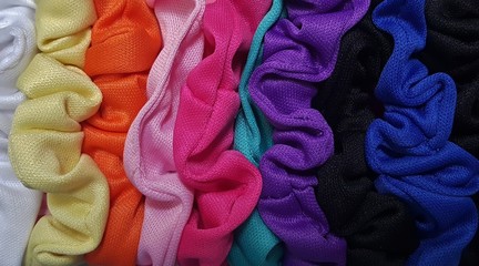 Colorful hair scrunchies arranged in a row.
