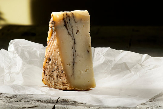 Wedge of pecorino with truffle on parchment paper