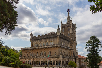Obraz premium The Bussaco Palace Hotel under a blue sky with white clouds