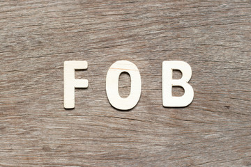 Alphabet letter in word FOB (abbreviation of free on board) on wood background