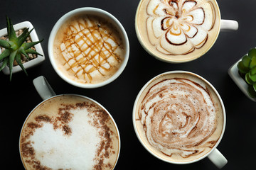 Cups with tasty aromatic coffee on black background, flat lay