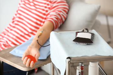 Woman with grip ball donating blood in hospital