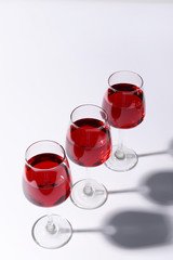 Glasses with sweet tasty wine on white background