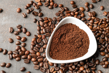 Bowl with coffee powder and beans on table