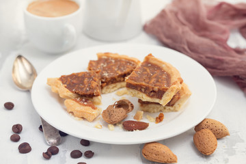 almond tart in small plate and cup of coffee