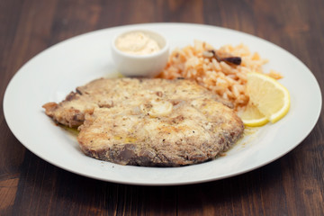 fried fish with rice and lemon on white plate