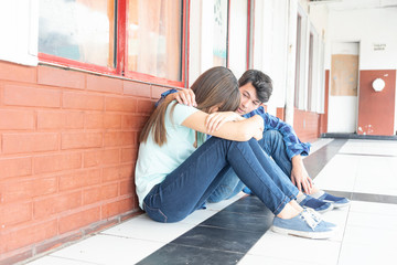 Teenagers couple at school. Boy conforting sad girl