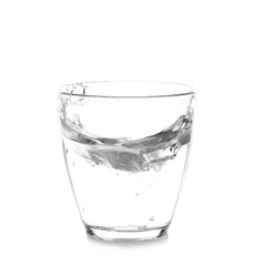 Glass with splashing water on white background