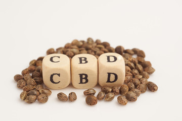 Alphabet cubes with cannabis seeds on white background CBD