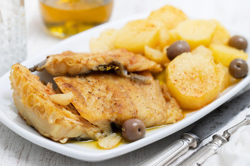 cod fish with fried potato on white dish