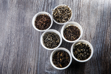 assorted tea leaves in six white small round vessels