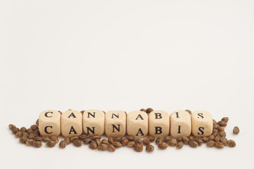 Alphabet cubes with cannabis seeds on white background