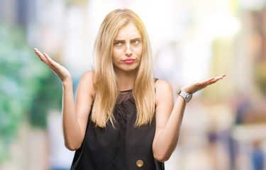Young beautiful blonde and blue eyes woman over isolated background clueless and confused...