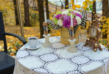 Decorated table in a street cafe against the background of autumn.