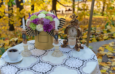 Decorated table in a street cafe against the background of autumn.