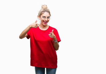 Young beautiful blonde woman wearing red t-shirt and glasses over isolated background pointing fingers to camera with happy and funny face. Good energy and vibes.