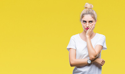 Young beautiful blonde woman wearing white t-shirt over isolated background thinking looking tired and bored with depression problems with crossed arms.