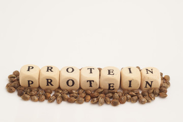 Alphabet cubes with cannabis seeds on white background protein