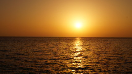 Sunset over Pacific Carribean beach showing dramatic red and yellow sky as sun sets 