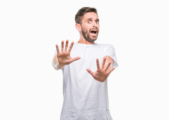 Young handsome man over isolated background afraid and terrified with fear expression stop gesture with hands, shouting in shock. Panic concept.