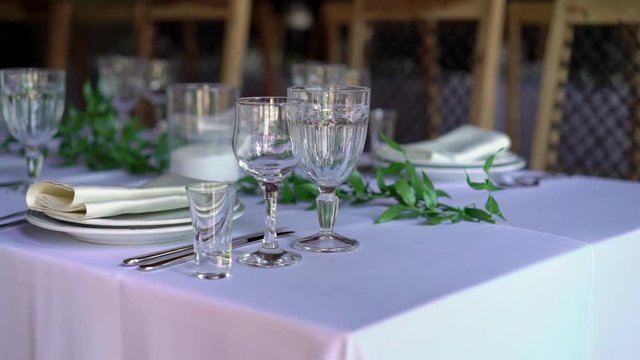 Banquet decorated table, with cutlery. Wedding decor in the banquet hall. Serving of a festive table, plate, napkin, knife, fork. Table setting decoration. Romantic Dinner or other events - wedding