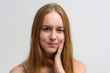 Studio portrait on the camera of a smiling beautiful girl with long hair talking on a white background with emotions.