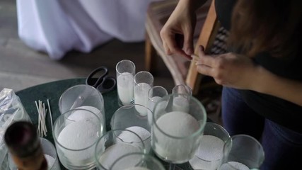 Making white candles indoors. Woman candle maker