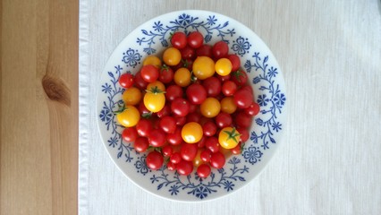 Plate full of red and yellow tomatos grown on balcony