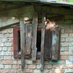old rusty wooden hatch in old brick wall