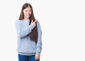 Young Chinese woman over isolated background cheerful with a smile of face pointing with hand and finger up to the side with happy and natural expression on face looking at the camera.