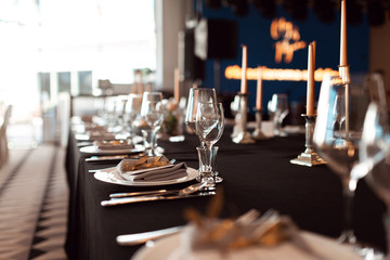 Sparkling glassware stands on table prepared for wedding. Wedding decor, interior. Festive. Banquet table