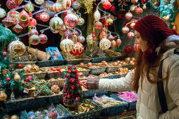 Shopping for Christmas Holidays, woman at market display window choosing Christmas tree...