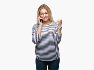 Obraz na płótnie Canvas Young caucasian woman showing smartphone screen over isolated background screaming proud and celebrating victory and success very excited, cheering emotion