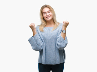 Young caucasian woman wearing winter sweater over isolated background celebrating surprised and amazed for success with arms raised and open eyes. Winner concept.