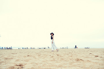traveler girl wearing hat standing posing relax on the beach