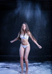 Obraz premium sporty young girl throws flour on black background