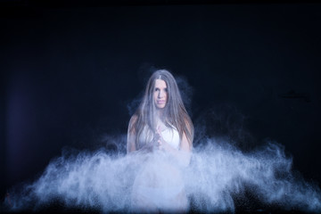 Fototapeta premium sporty young girl throws flour on black background