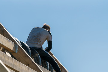 Man climbing over an obstacle at an obstacle course race