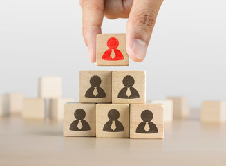 Hand arranging wooden blocks stacking as a pyramid staircase on white background. Leadership, Human...