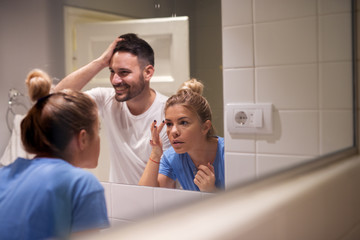 Fototapeta premium Close up of a young tired couple early in a morning preparing them selves for the work.