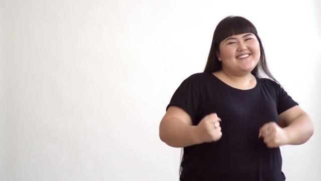 Authentic Fat Asian Girl Dancing And Enjoying Life On White Background. Life Outside Of The Stereotypes Of Today's Youth. Concept Idea