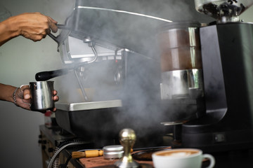 Barista making  fresh espresso with a classic Italian coffee machine with steam in background. barista Coffee Maker Machine Grinder Portafilter Concept