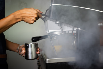 Barista making  fresh espresso with a classic Italian coffee machine with steam in background. barista Coffee Maker Machine Grinder Portafilter Concept